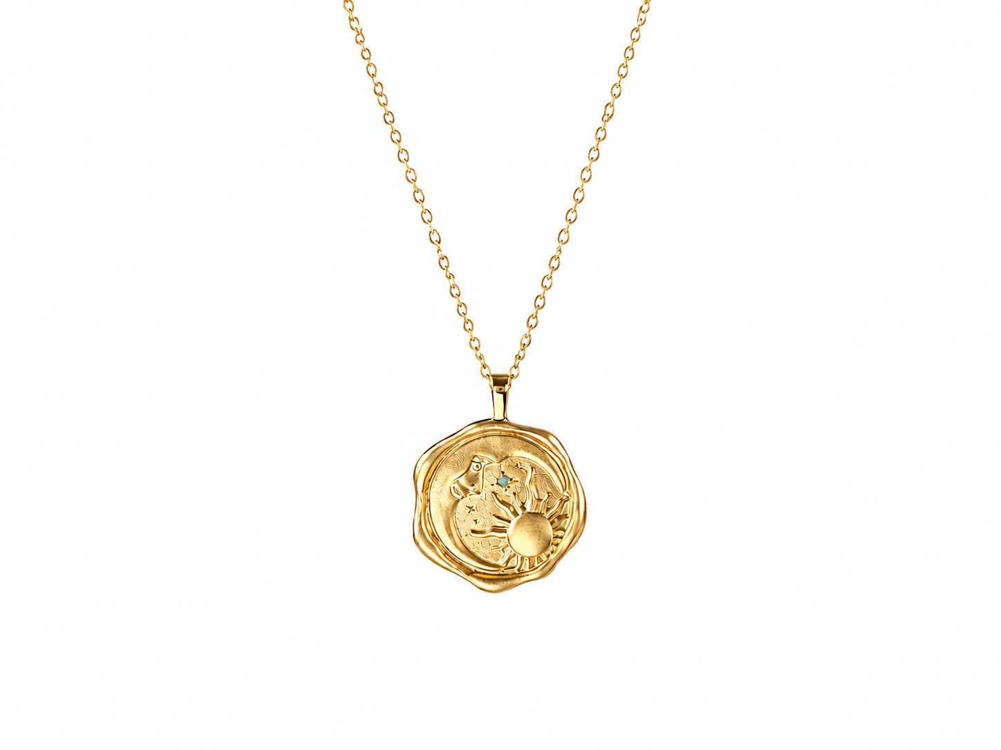 A gold pendant necklace featuring a textured, circular wax seal design with an embossed sun motif, suspended from a delicate gold chain against a solid white background.